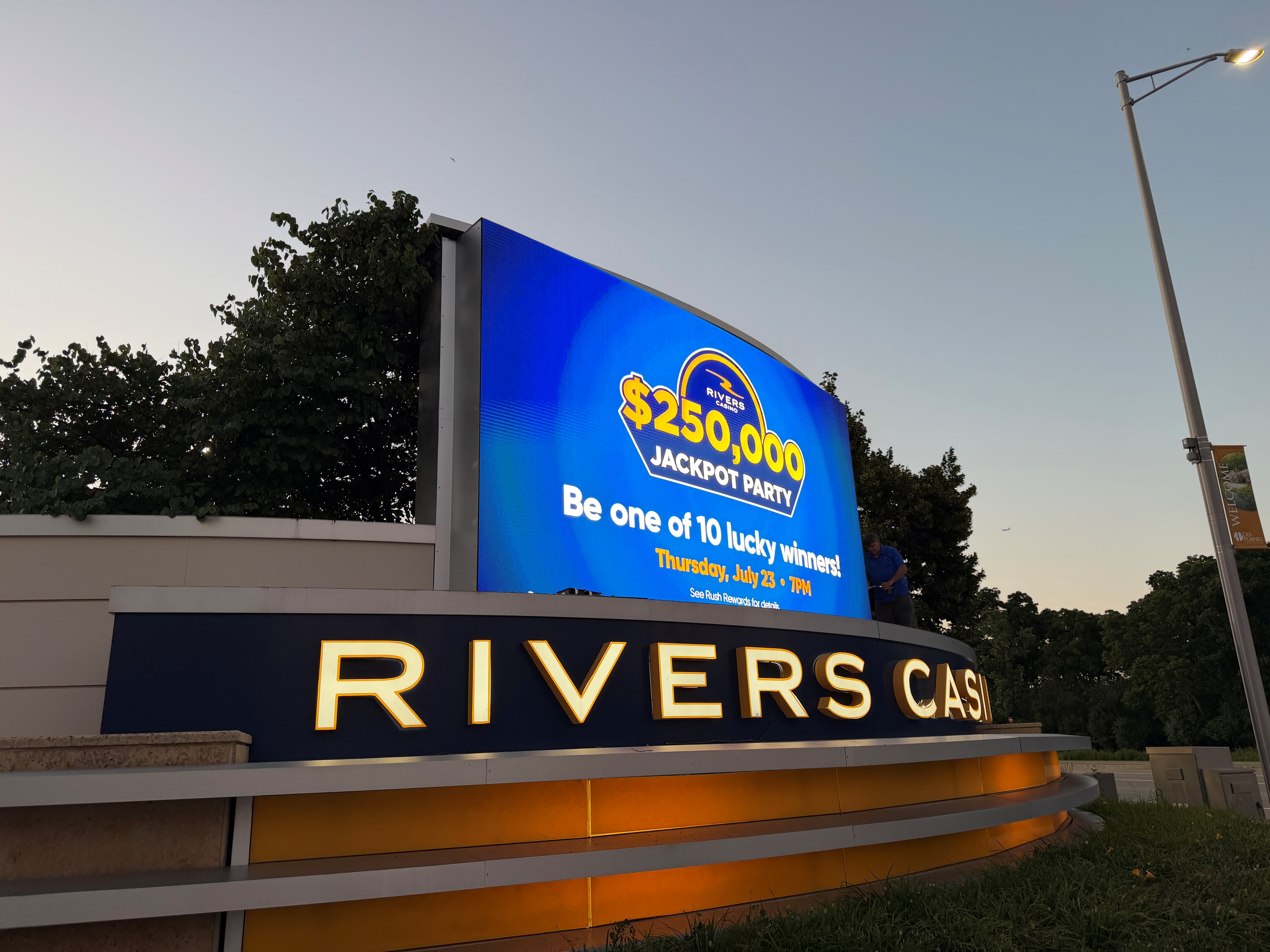 Rivers Casino Des Plaines outdoor marquee LED display showing $250,000 Jackpot Party promotion at dusk